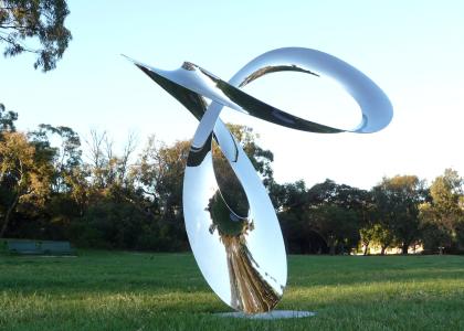 Large swooping and shiny metal sculpture in park