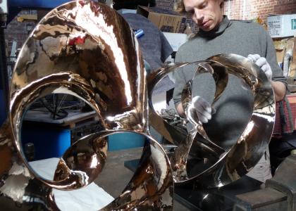 Artist Ben Storch polishing his metal sculpture