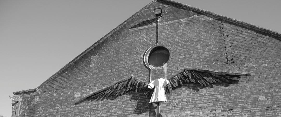 Black and White image of The Angel sculpture on the exterior of the Gasworks Theatre building. 