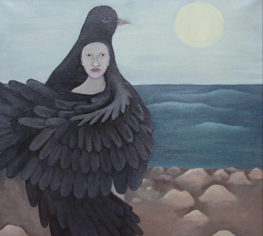 painting of a person on the rocky shore enveloped by a black birds wings. The sky is blue over the ocean and the sun shines brightly.